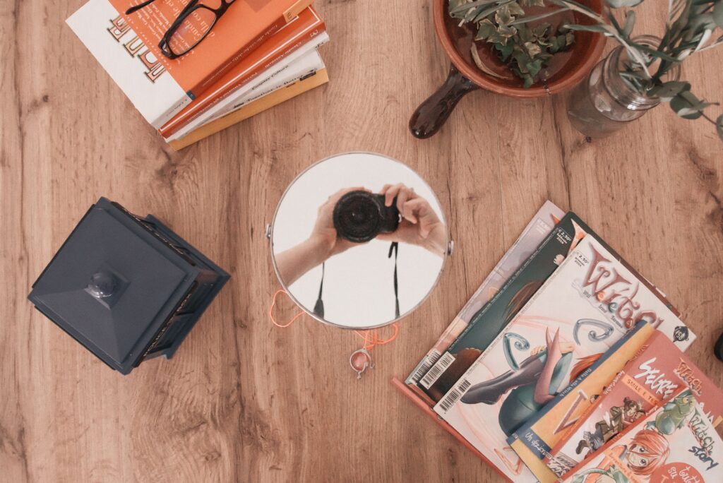 Come fare collaborazioni sui social flatlay dall'alto tavolo con libri riviste e specchio